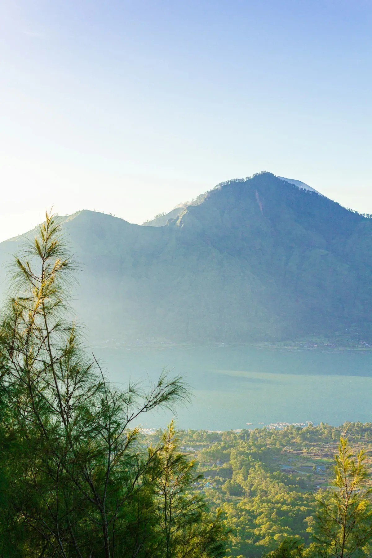 Panoramic golden sunrise reflection across Lake Batur caldera seen from the 4x4 jeep summit point